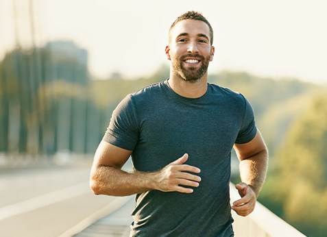 Man running outdoors and smiling
