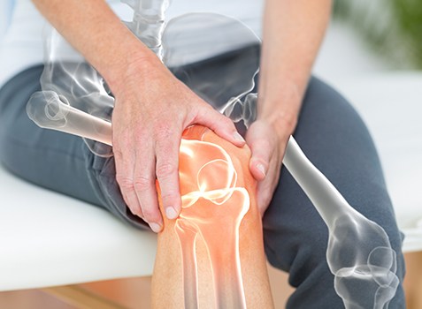Patient with knee pain holding leg