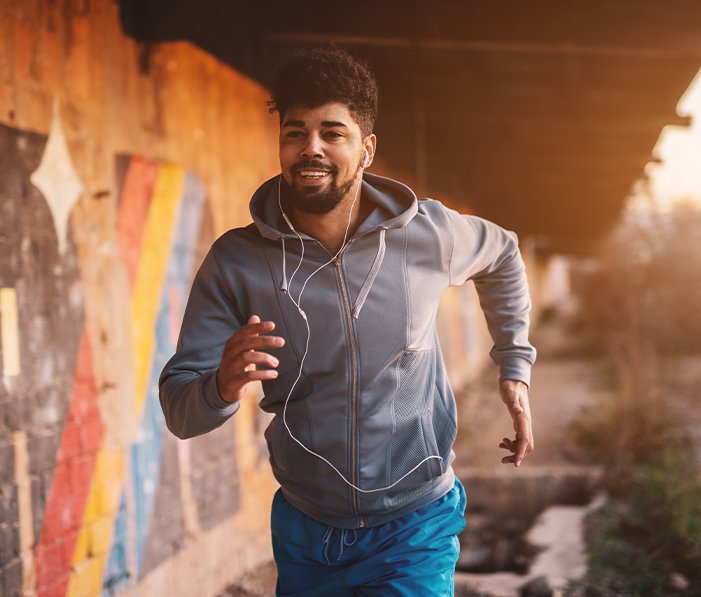 Man jogging happily after receiving holistic medicine treatment
