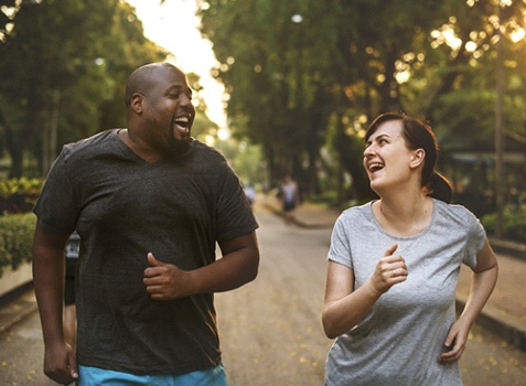Happy man and woman jogging outside for weight loss