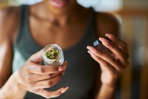 Woman with jar of medicinal marijuana, wondering how to take it