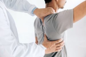 Doctor touching patient’s shoulder during OMT session