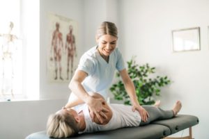 Doctor helping patient stretch during muscle energy session